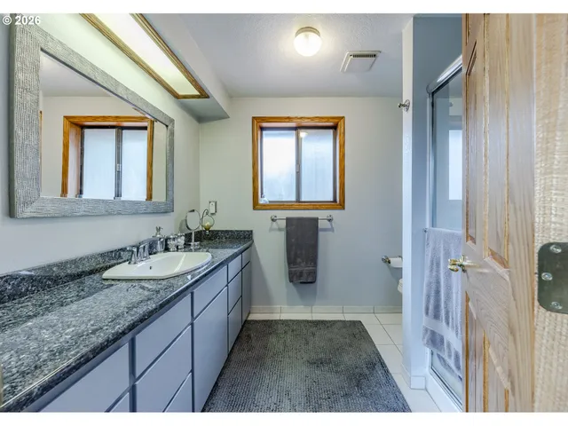 a bathroom with a granite countertop sink mirror and double