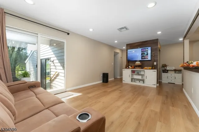 a living room with furniture and a open kitchen view