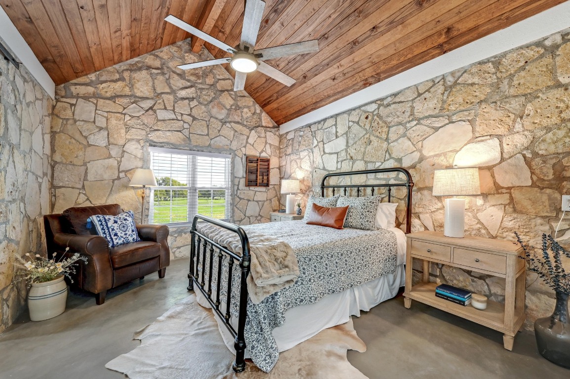 1668 Rocky Road Blanco, TX 78606 - Photo 20 of 33 a bedroom with a bed couch and a fireplace