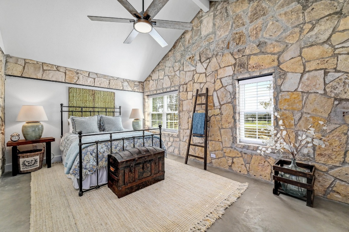 1668 Rocky Road Blanco, TX 78606 - Photo 23 of 33 a spacious bedroom with a bed a couch and dresser