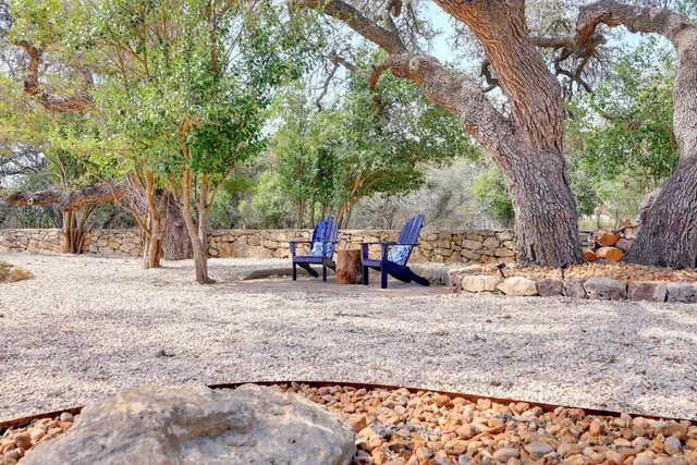 a view of a backyard with table and chairs and a large tree