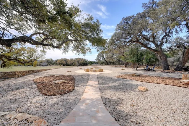 a view of dirt yard with a large tree