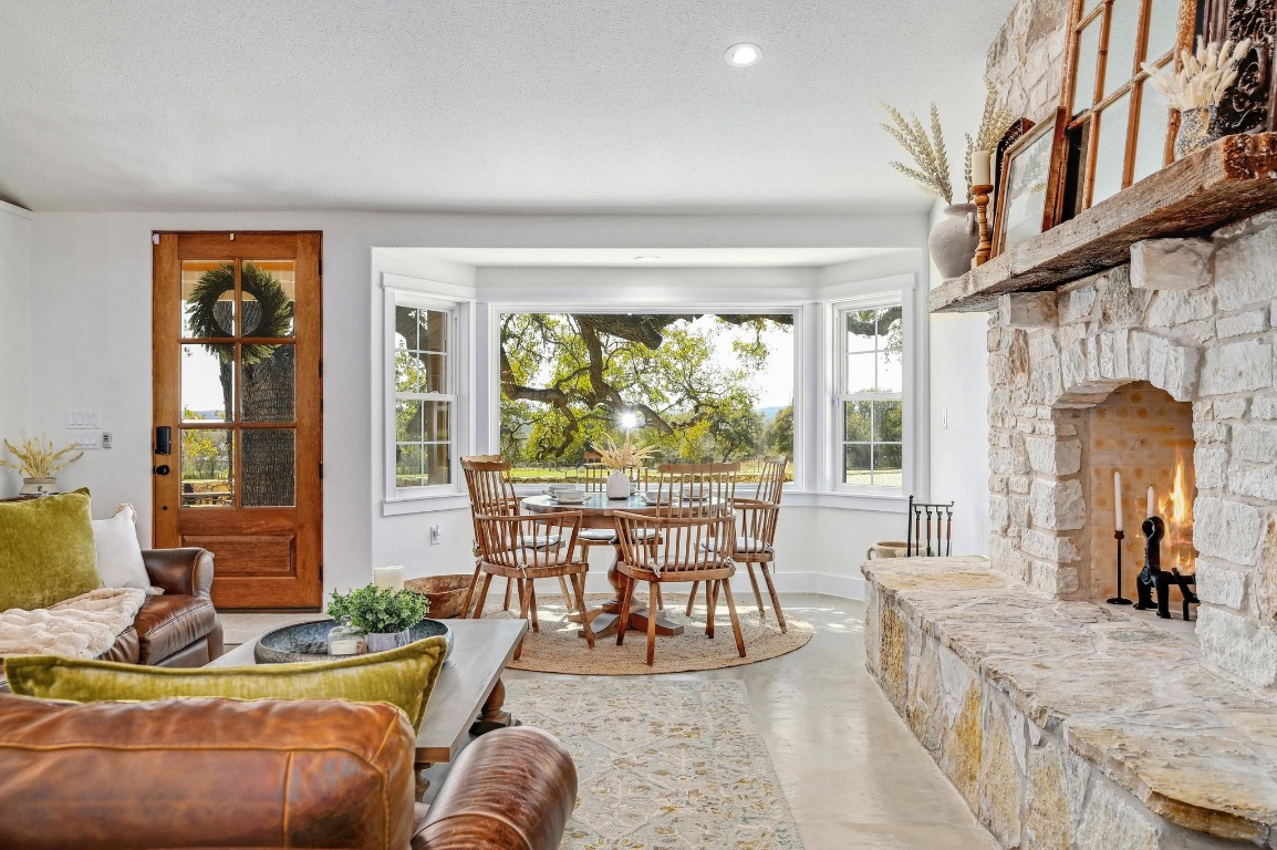 1668 Rocky Road Blanco, TX 78606 - Photo 8 of 33 a living room with furniture a fireplace and large windows