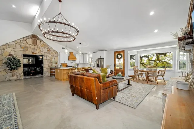 a living room with furniture a fireplace and a chandelier
