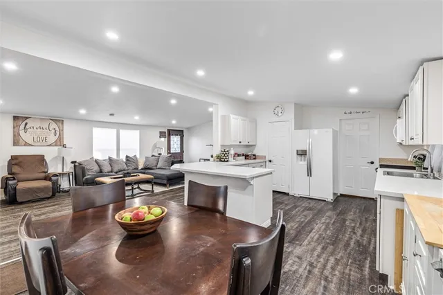 a kitchen with a sink and white cabinets with wooden floor