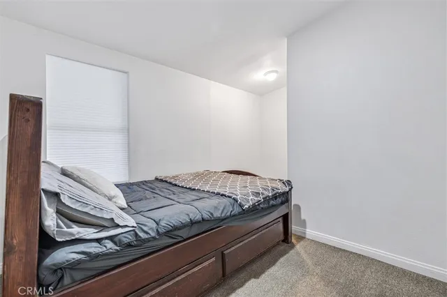 a bed sitting in a bedroom next to a window
