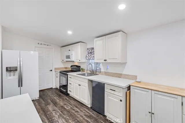 a kitchen with white cabinets appliances and sink