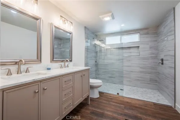 a bathroom with a double vanity sink toilet and shower