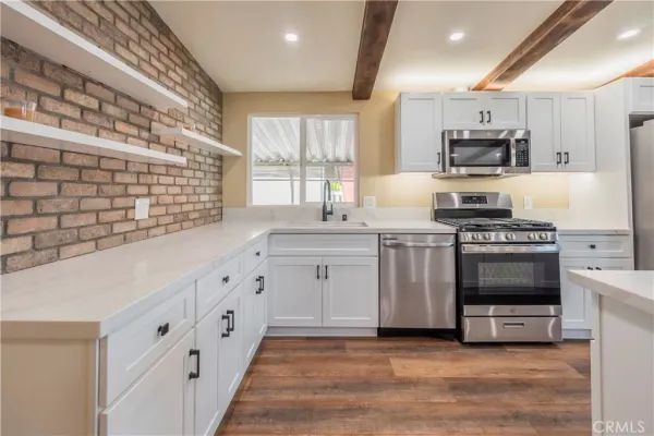 a kitchen with stainless steel appliances a stove sink microwave and cabinets