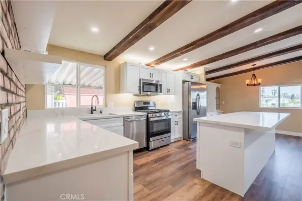 a kitchen with stainless steel appliances granite countertop a sink a stove and a refrigerator