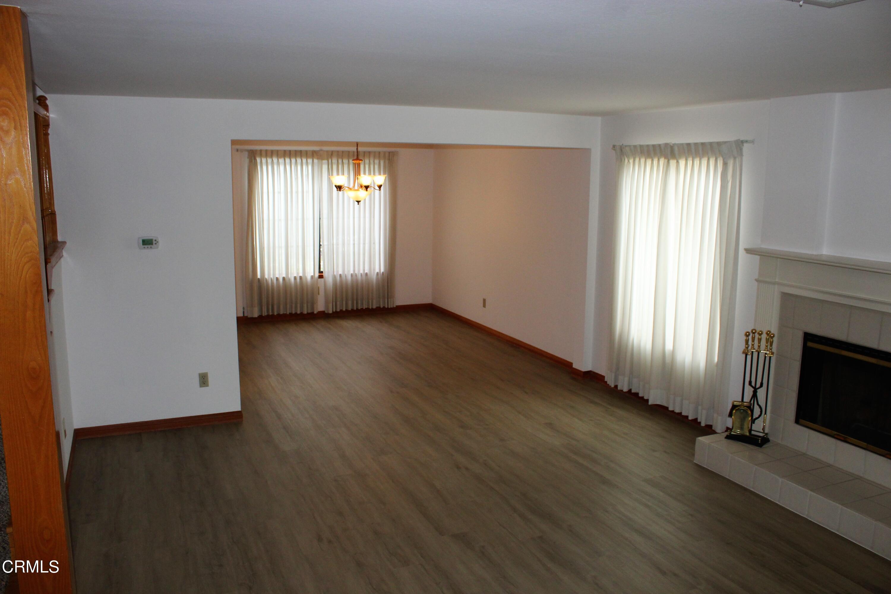 2202 Firestone Court Oxnard, CA 93036 - Photo 15 of 51 an empty room with wooden floor fireplace and windows