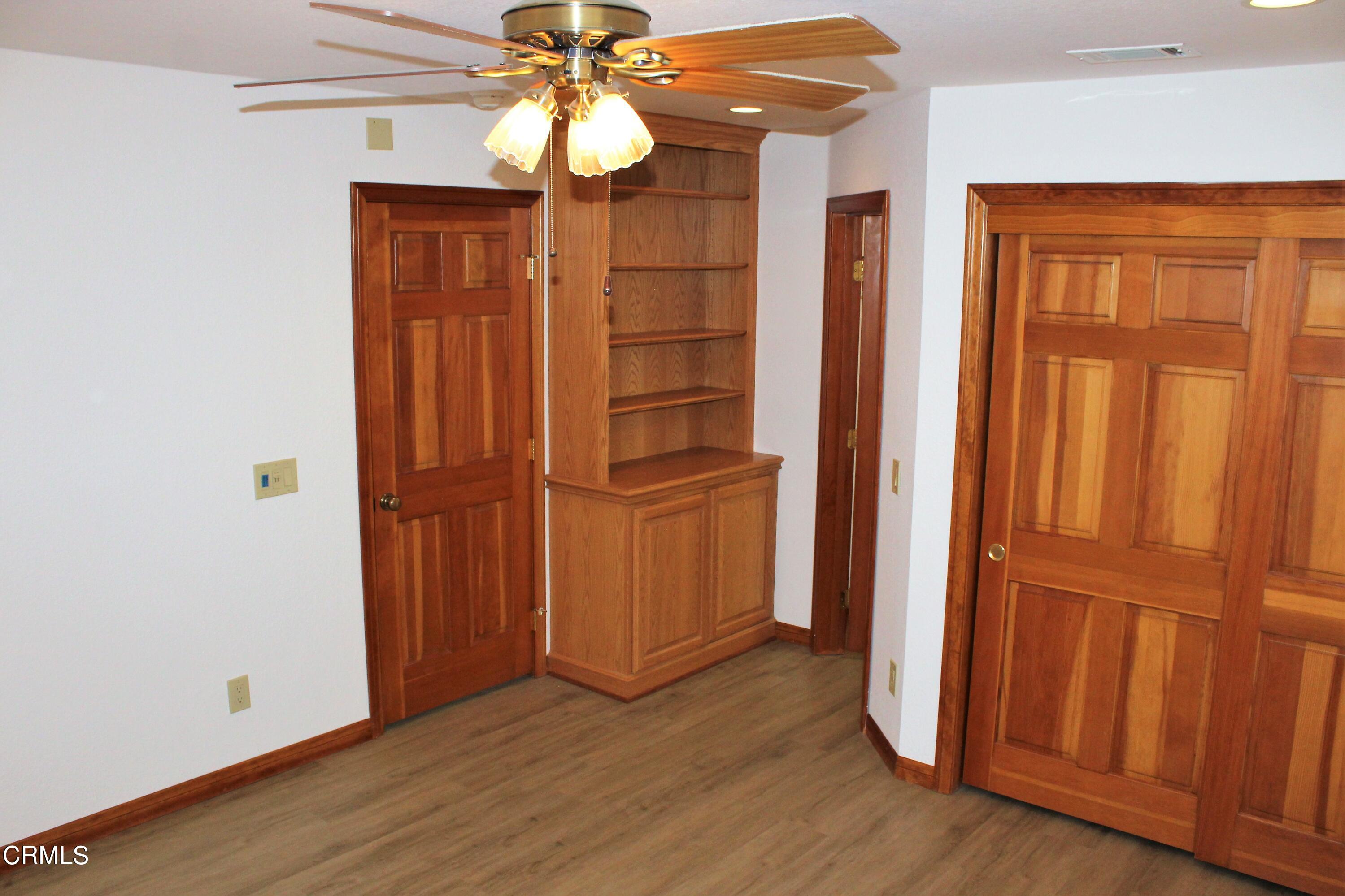 2202 Firestone Court Oxnard, CA 93036 - Photo 20 of 51 an empty room with wooden floor stairs and a chandelier fan