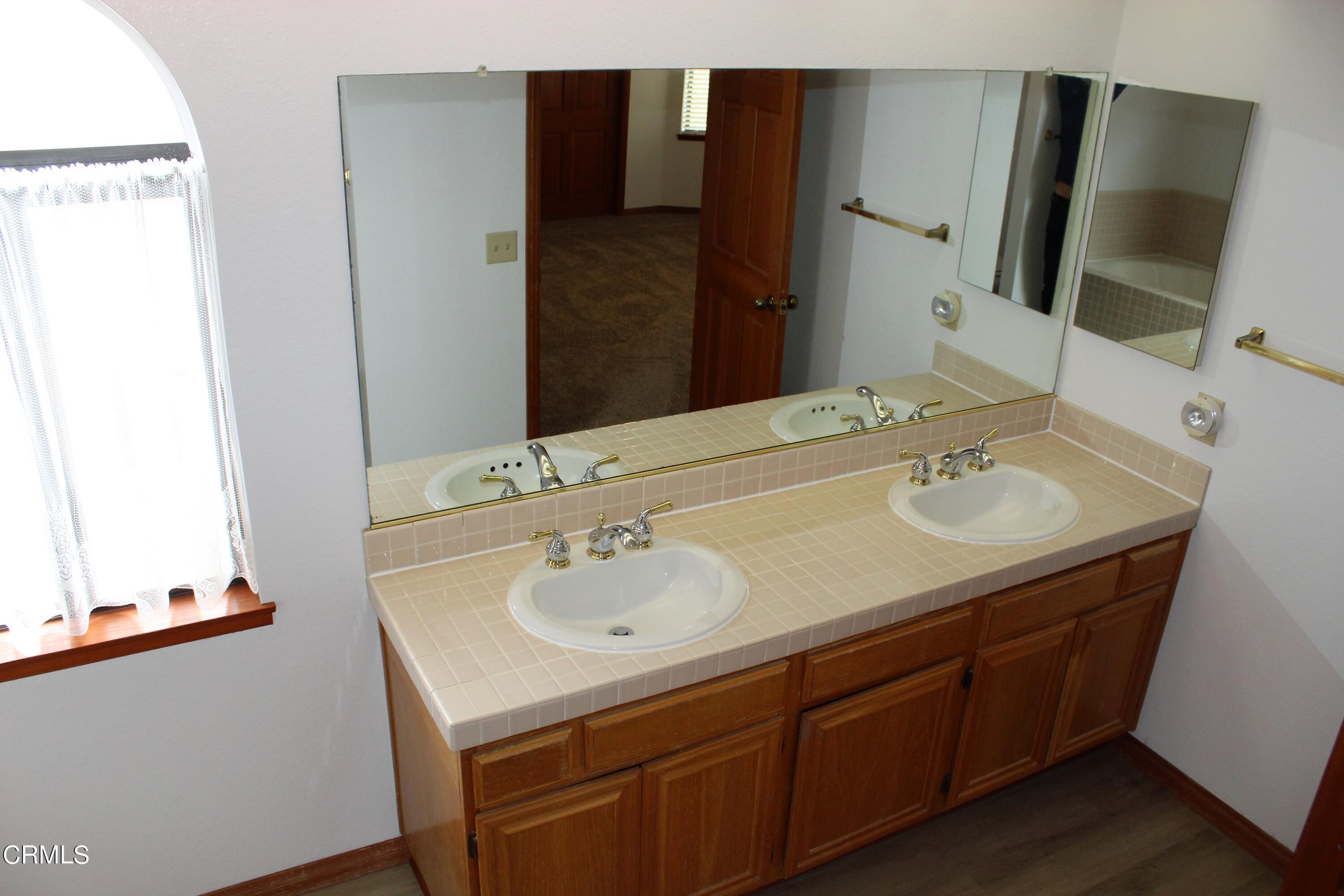 2202 Firestone Court Oxnard, CA 93036 - Photo 34 of 51 a bathroom with a sink and a mirror