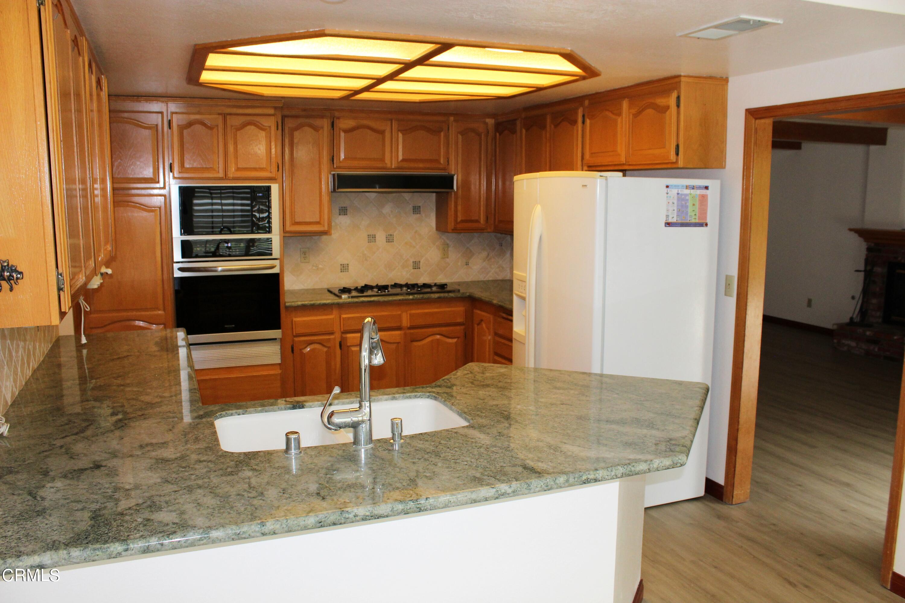 2202 Firestone Court Oxnard, CA 93036 - Photo 7 of 51 a kitchen with kitchen island a sink a stove and a refrigerator