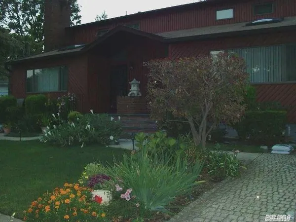 a backyard of a house with lots of green space and plants