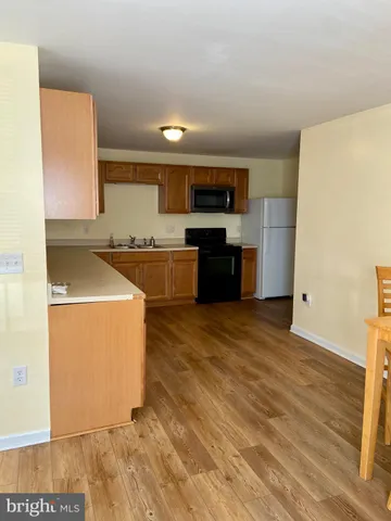 a kitchen with stainless steel appliances granite countertop a stove top oven a sink dishwasher and granite countertops with wooden floor