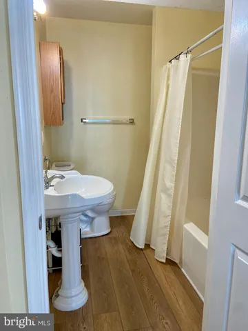 a bathroom with a sink a toilet and shower curtain