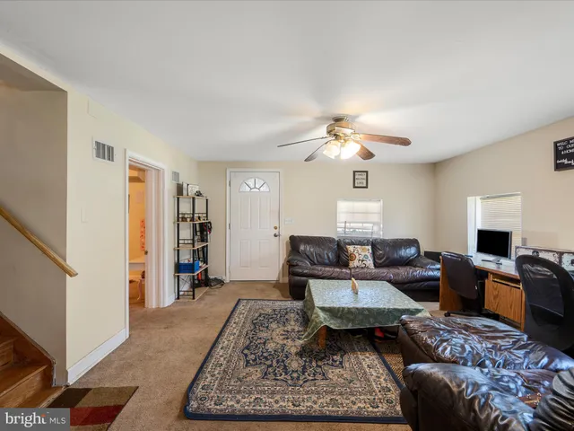 a living room with furniture ceiling fan and a wooden floor