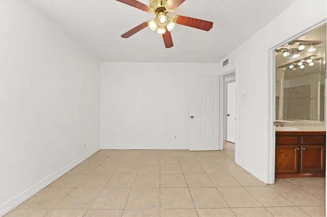 an empty room with closet and windows