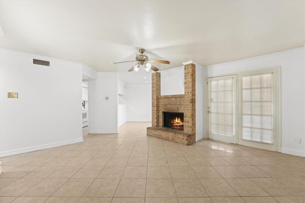 16301 Ledgemont Lane, Unit 109 Addison, TX 75001 - Photo 7 of 32 an empty room with fireplace and windows