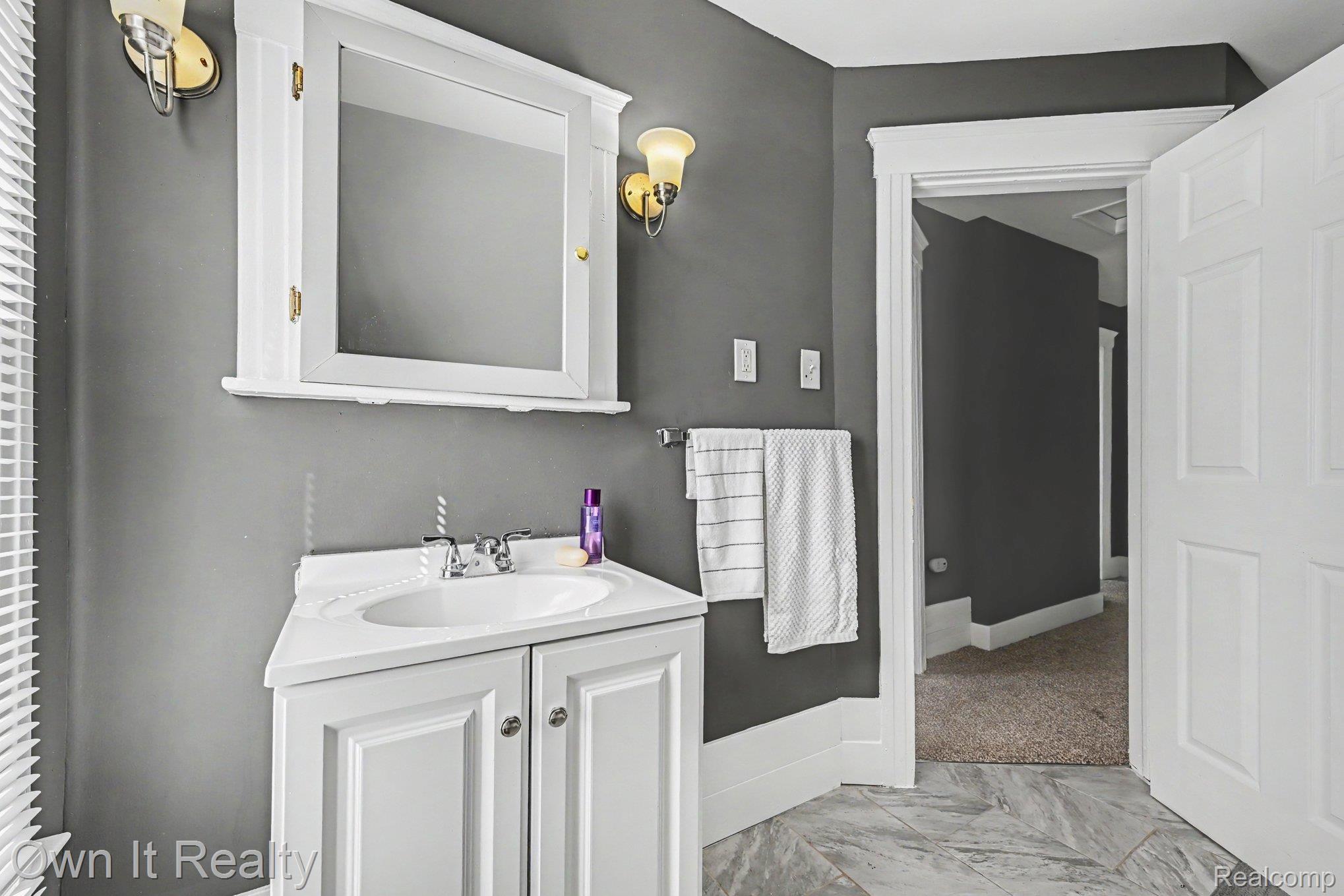 44 Maple Street River Rouge, MI 48218 - Photo 21 of 33 Vanity with an integrated sink, polished chrome faucet, and white paneled cabinetry