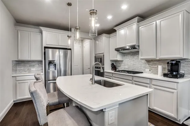 a kitchen with a dining table chairs stainless steel appliances and cabinets