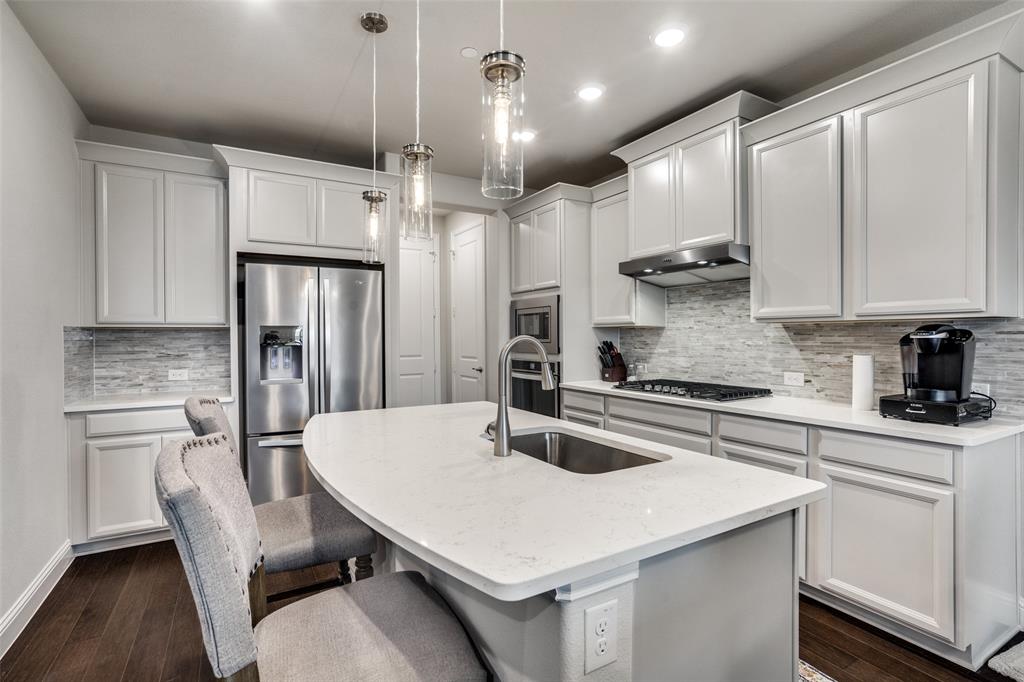 5622 Niagara Road The Colony, TX 75056 - Photo 12 of 28 a kitchen with granite countertop a stove a sink a kitchen island with a refrigerator and cabinets