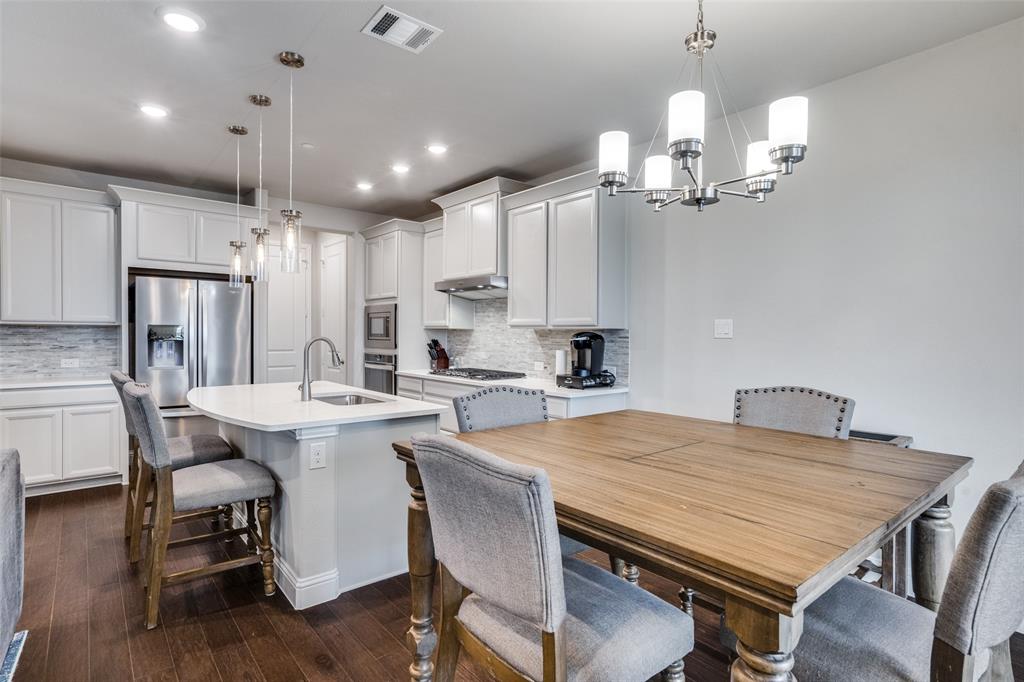 5622 Niagara Road The Colony, TX 75056 - Photo 13 of 28 a kitchen with a dining table chairs stainless steel appliances and cabinets