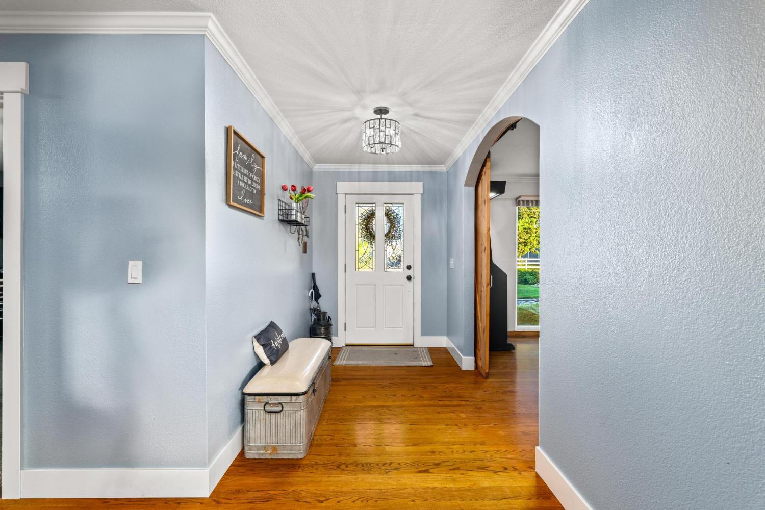 13791 Castle Road Manteca, CA 95336 - Photo 14 of 96 foyer with a textured wall, arched walkways, wood finished floors, ornamental molding, and a chandelier