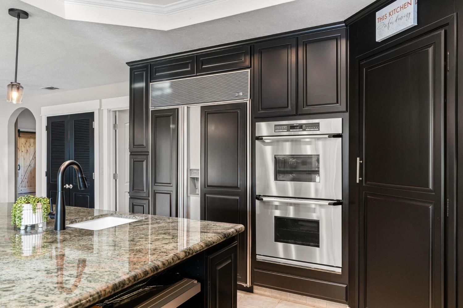 13791 Castle Road Manteca, CA 95336 - Photo 24 of 96 a kitchen with kitchen island a counter top space cabinets and stainless steel appliances
