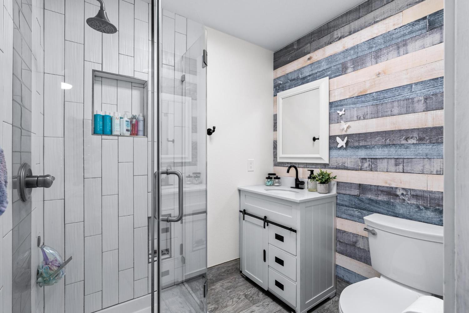 13791 Castle Road Manteca, CA 95336 - Photo 35 of 96 Ensuite full bath with wooden walls, vanity, and a stall shower