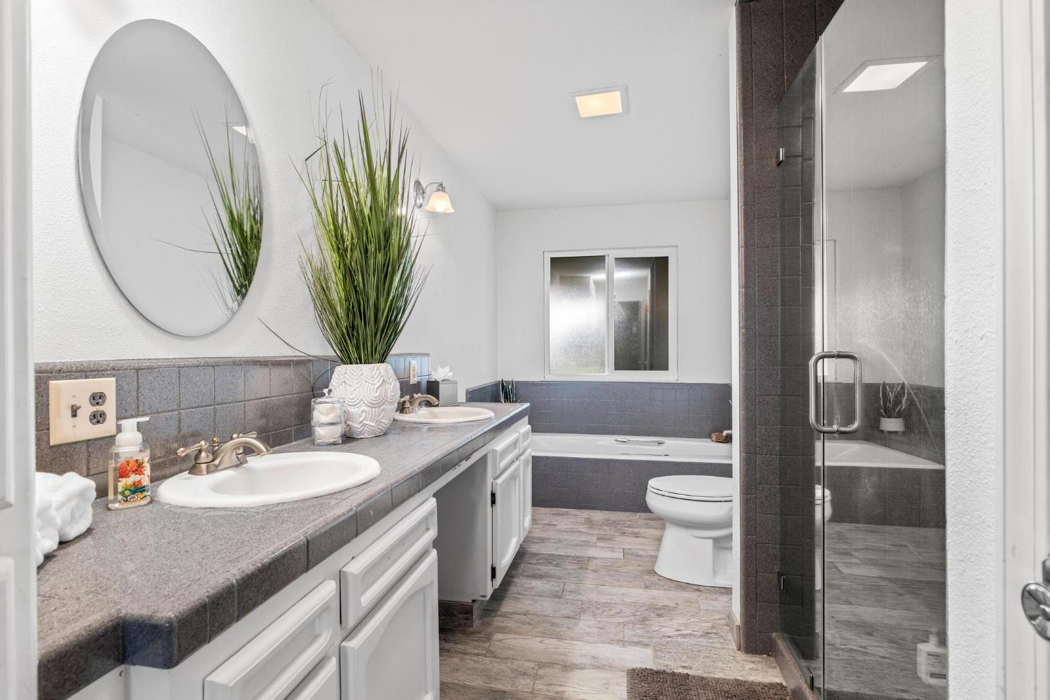 13791 Castle Road Manteca, CA 95336 - Photo 37 of 96 a bathroom with a granite countertop toilet sink and mirror