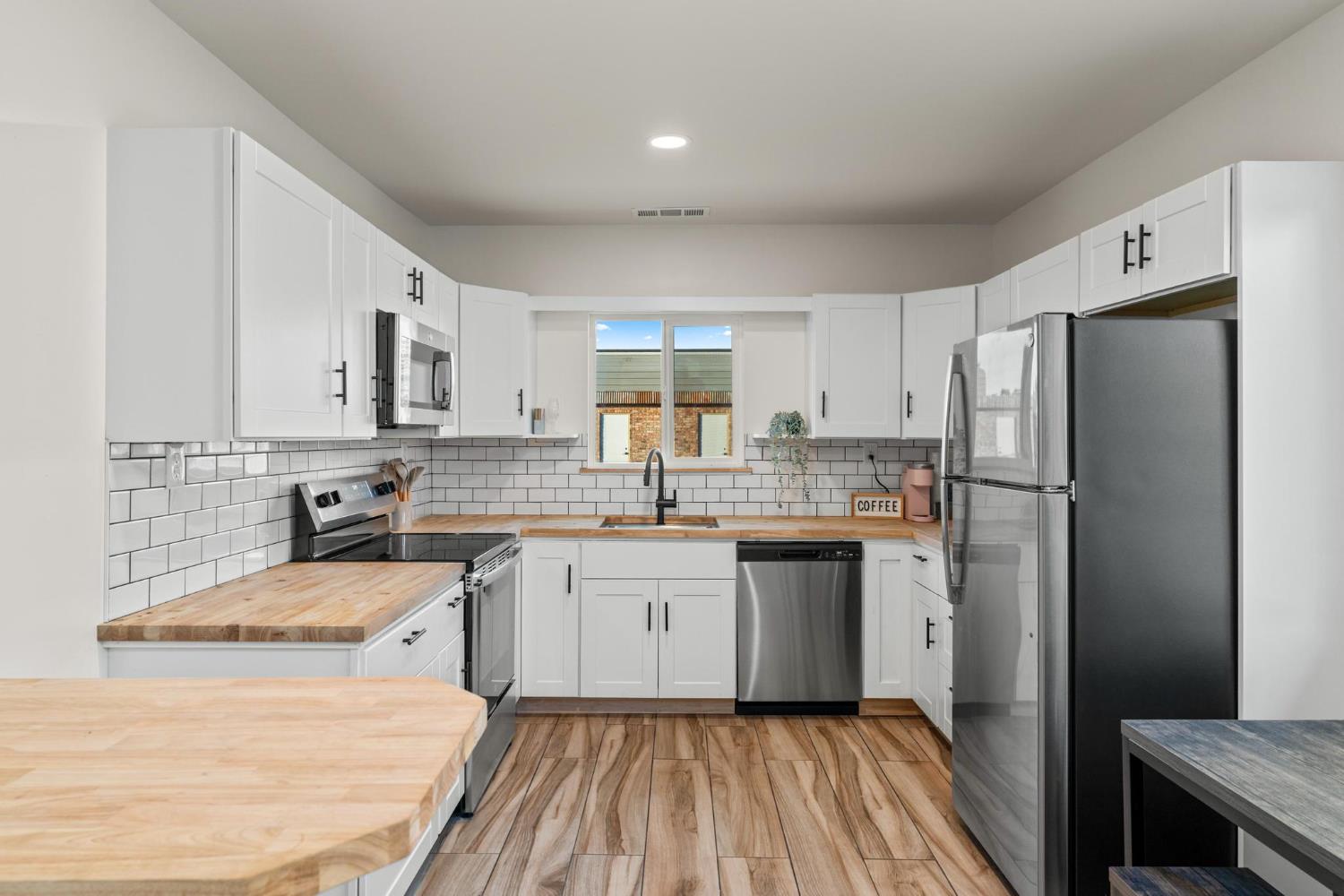 13791 Castle Road Manteca, CA 95336 - Photo 55 of 96 a kitchen with a refrigerator a sink and dishwasher a oven with white cabinets