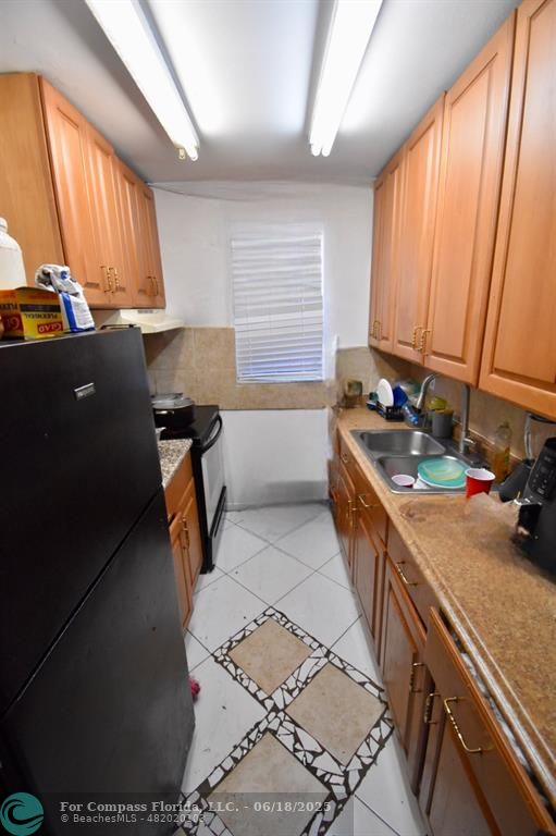 650 Southwest 2nd Avenue, Unit 256 Boca Raton, FL 33432 - Photo 5 of 13 a kitchen with a sink a window and chairs