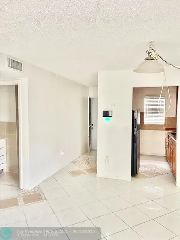 a view of a refrigerator in kitchen and a living room