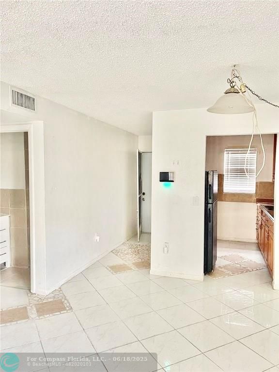 650 Southwest 2nd Avenue, Unit 256 Boca Raton, FL 33432 - Photo 6 of 13 a view of a refrigerator in kitchen and a living room