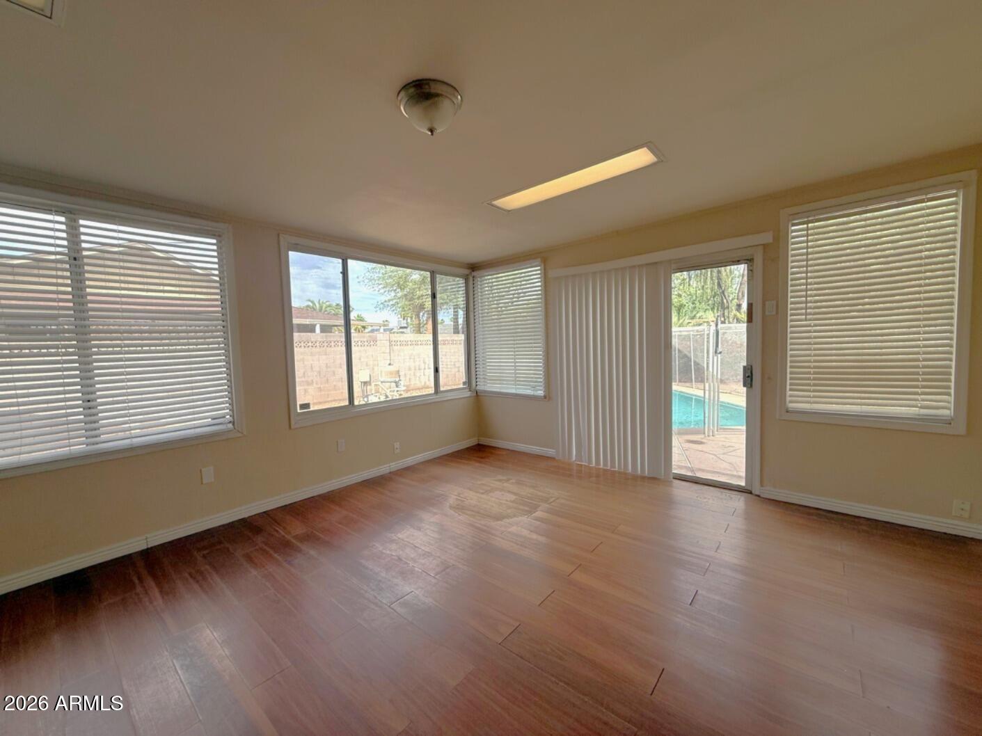 4625 South Rita Lane Tempe, AZ 85282 - Photo 11 of 16 a view of an empty room with wooden floor and a window