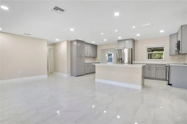 a view of a kitchen with a sink and dishwasher a refrigerator with white cabinets
