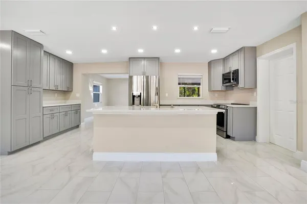 a large kitchen with stainless steel appliances granite countertop a large counter top and a stove top oven