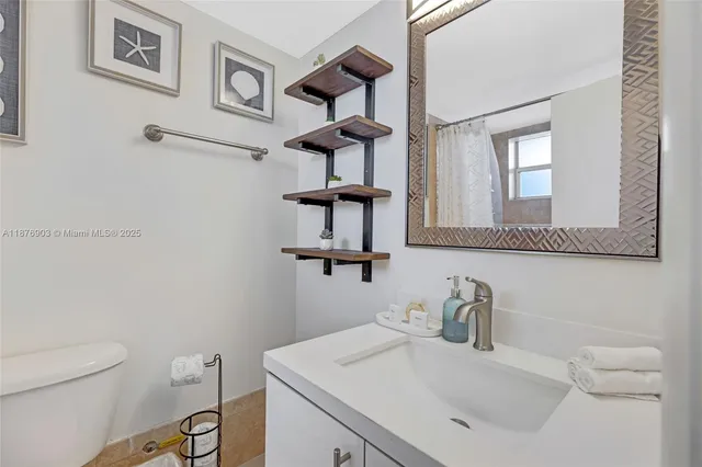 a bathroom with a sink vanity mirror and toilet