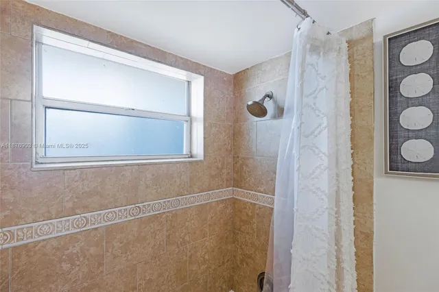 a bathroom with a glass shower door and a sink