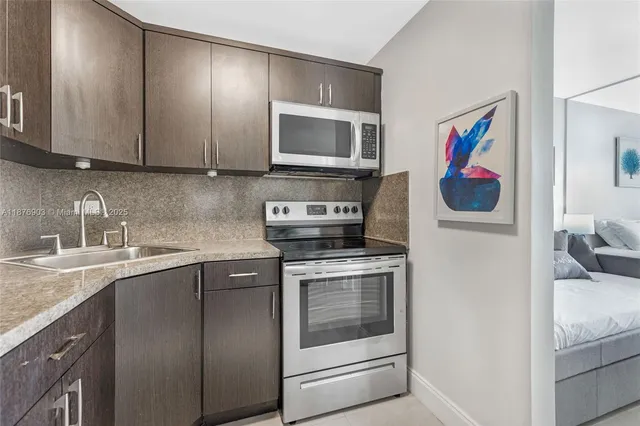 a kitchen with stainless steel appliances granite countertop a stove a sink and a microwave