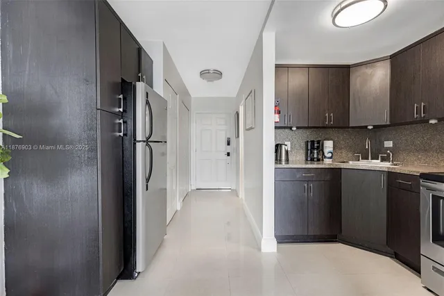 a kitchen with stainless steel appliances granite countertop a refrigerator and a sink