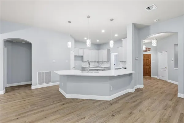 a large kitchen with kitchen island a sink stainless steel appliances and cabinets