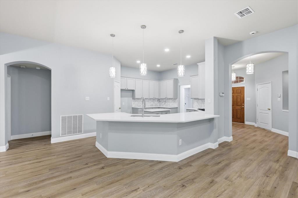 2616 Hollow Ridge Drive Denton, TX 76210 - Photo 1 of 31 Open-concept kitchen featuring a spacious island with a white countertop and three pendant lights