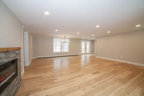 a view of empty room with wooden floor and fireplace