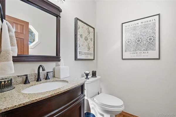 a bathroom with a granite countertop toilet sink and mirror