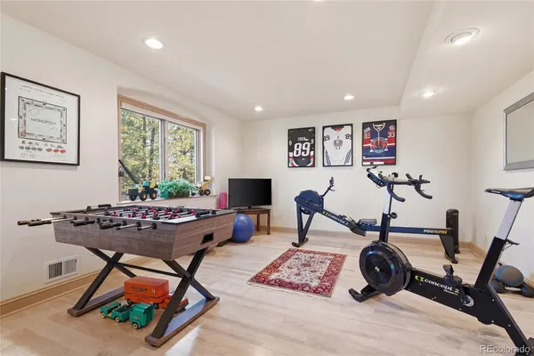 a living room with furniture a window and gym equipment