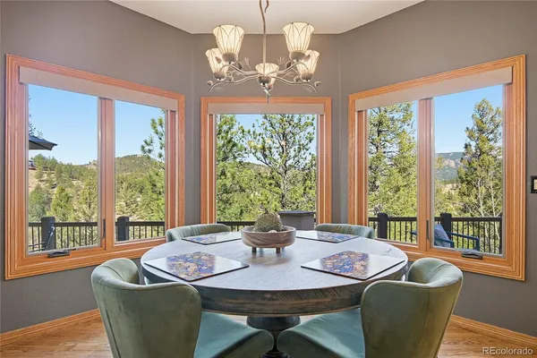 a dining room with furniture a chandelier and wooden floor