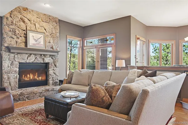 a living room with furniture a fireplace and a large window